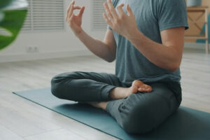 マットの上でヨガのポーズをとる男性