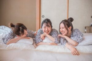 浴衣を来て布団で寝転ぶ女子3人組