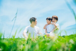 天気の良い日にピクニックをする小さい子供と若い夫婦