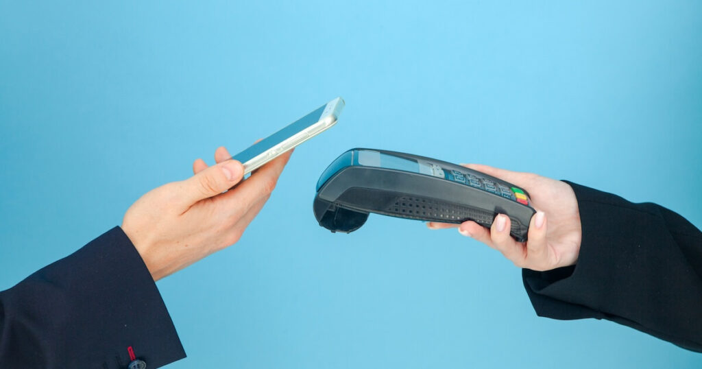 スマートフォンを使ってタッチ決済する人