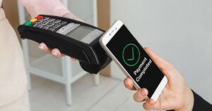 スマートフォンを決済端末にタッチして支払う人