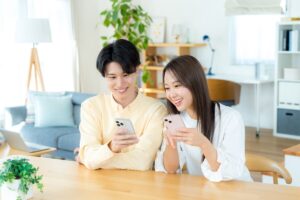 スマホの画面を見る若い日本人カップル